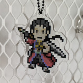 An acrylic charm featuring a pixel young Auron